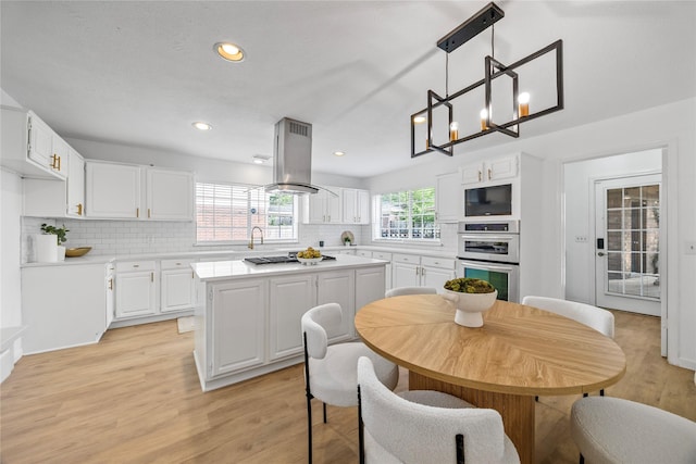 10310 Minturn Ln, Houston, TX 77064 - kitchen with decorative backsplash, white cabinets, double oven, light wood finished floors, and recessed lighting