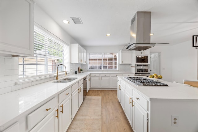 10310 Minturn Ln, Houston, TX 77064 - kitchen featuring a sink, island exhaust hood, stainless steel appliances, a center island, and light wood-style flooring