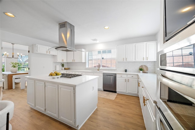10310 Minturn Ln, Houston, TX 77064 - kitchen with island exhaust hood, stainless steel appliances, healthy amount of natural light, light wood-style floors, and recessed lighting