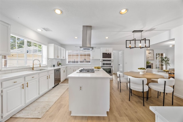 10310 Minturn Ln, Houston, TX 77064 - kitchen with appliances with stainless steel finishes, a sink, island exhaust hood, a kitchen island, and decorative backsplash