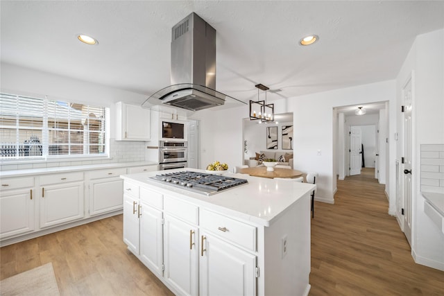 10310 Minturn Ln, Houston, TX 77064 - kitchen featuring stainless steel gas stovetop, island range hood, a kitchen island, light countertops, and recessed lighting