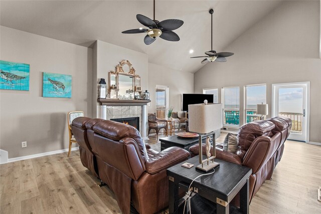 23313 San Luis Pass Rd, Galveston, TX 77554 - living room with ceiling fan, light wood-type flooring, a fireplace, high vaulted ceiling, and baseboards