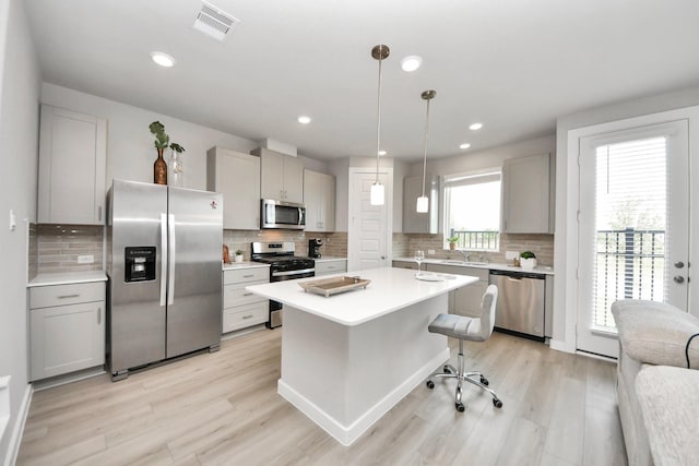 10053 Cloud Mist Dr, Houston, TX 77080 - kitchen with stainless steel appliances, decorative backsplash, light wood-style floors, gray cabinetry, and recessed lighting