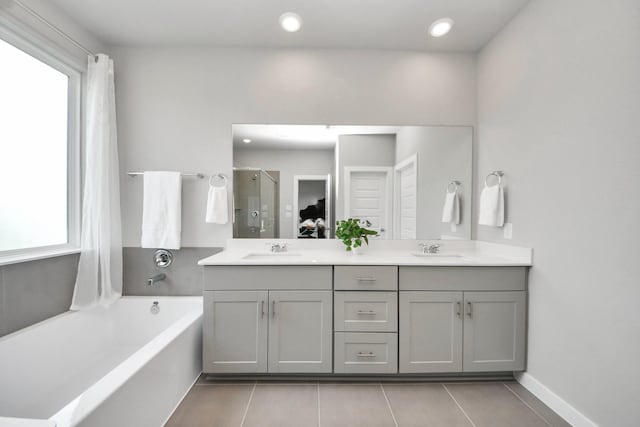 10053 Cloud Mist Dr, Houston, TX 77080 - bathroom featuring plenty of natural light, tile patterned flooring, a bath, double vanity, and recessed lighting