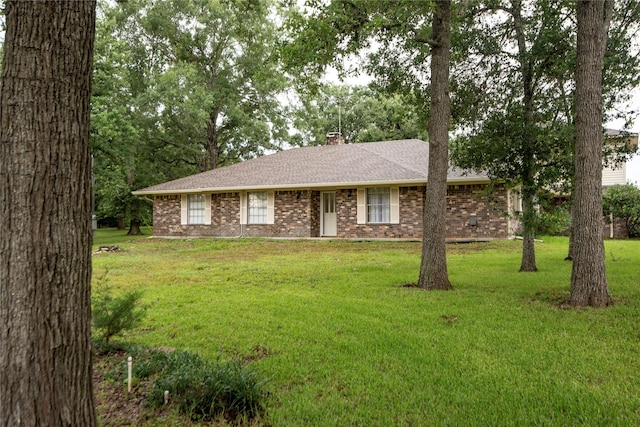 5150 Sandy Creek Ln, Brenham, TX 77833 - single story home with brick siding, roof with shingles, a front yard, and a chimney