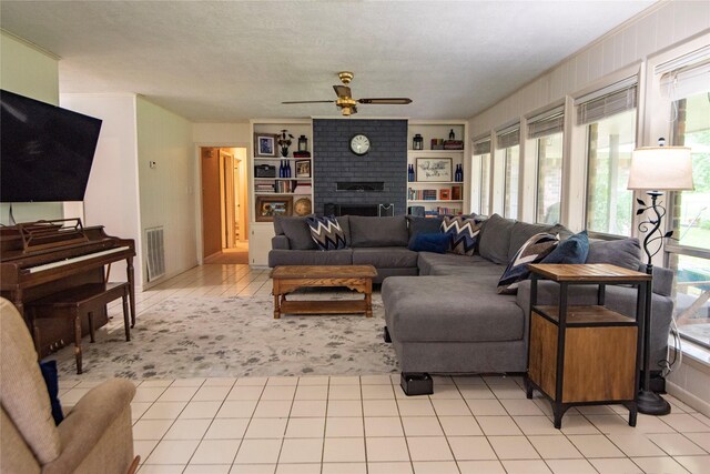 5150 Sandy Creek Ln, Brenham, TX 77833 - living area featuring a ceiling fan, a fireplace, and light tile patterned flooring
