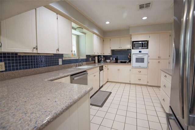 5150 Sandy Creek Ln, Brenham, TX 77833 - kitchen with appliances with stainless steel finishes, a sink, light tile patterned floors, backsplash, and recessed lighting