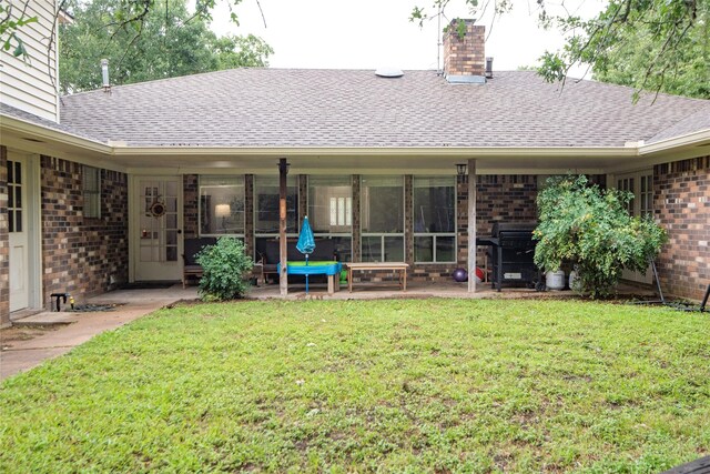 5150 Sandy Creek Ln, Brenham, TX 77833 - back of house with brick siding, a shingled roof, a lawn, and a chimney