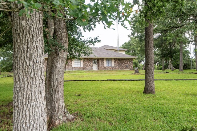 5150 Sandy Creek Ln, Brenham, TX 77833 - view of front of home with brick siding, a front lawn, and a shingled roof