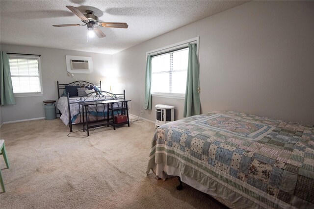 5150 Sandy Creek Ln, Brenham, TX 77833 - bedroom featuring a wall mounted air conditioner, carpet floors, multiple windows, baseboards, and a textured ceiling