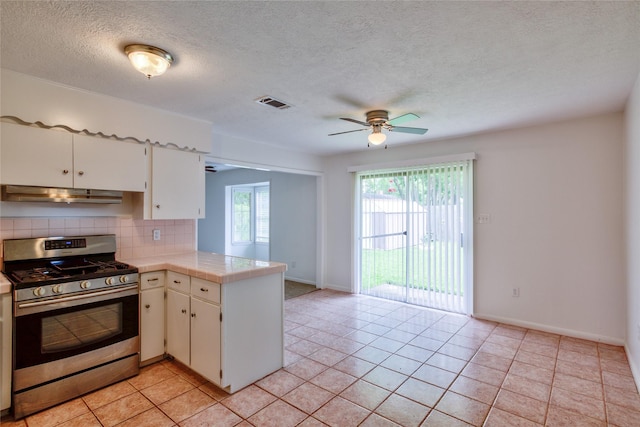 705 Kalmer St, Pasadena, TX 77502 - kitchen featuring stainless steel gas stove, a peninsula, a ceiling fan, backsplash, and baseboards