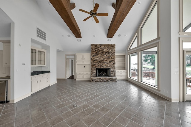 22 Creekwood Dr, Montgomery, TX 77356 - unfurnished living room with a stone fireplace, high vaulted ceiling, beamed ceiling, dark tile patterned floors, and ceiling fan