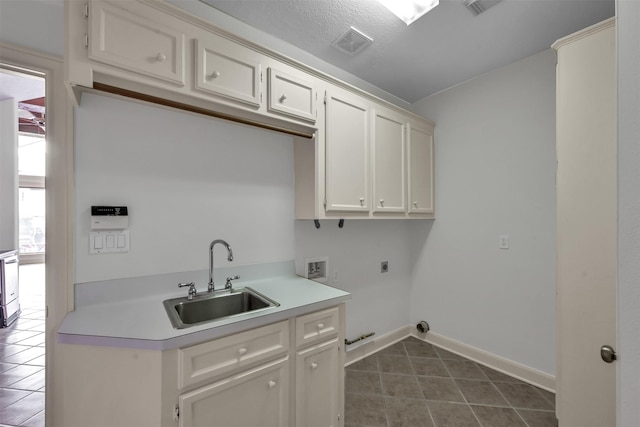 22 Creekwood Dr, Montgomery, TX 77356 - washroom with hookup for an electric dryer, dark tile patterned flooring, washer hookup, baseboards, and cabinet space