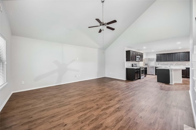 5627 Rainflower Terrace Ln, Spring, TX 77389 - unfurnished living room featuring a ceiling fan, light wood-style floors, baseboards, a sink, and high vaulted ceiling