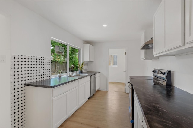 5511 Hickory Forest Dr, Houston, TX 77088 - kitchen featuring stainless steel appliances, a sink, dark countertops, ventilation hood, and white cabinets