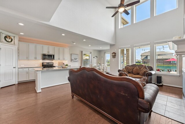 3651 Lake Bend Shore Dr, Spring, TX 77386 - living area featuring wood finished floors, healthy amount of natural light, ceiling fan, recessed lighting, and a high ceiling