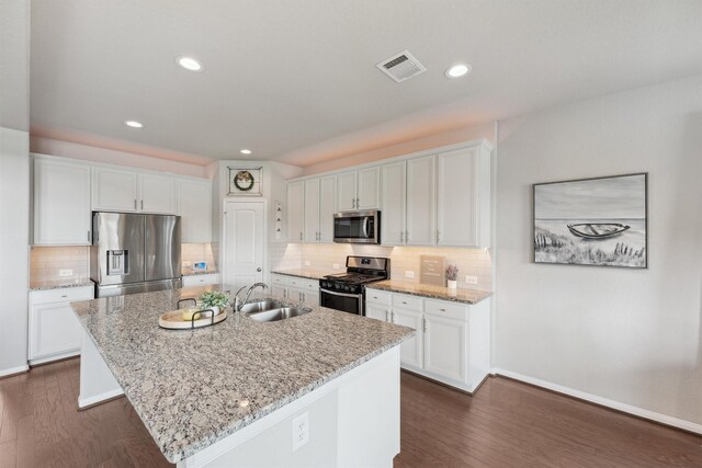 3651 Lake Bend Shore Dr, Spring, TX 77386 - kitchen featuring appliances with stainless steel finishes, a sink, dark wood finished floors, white cabinetry, and an island with sink