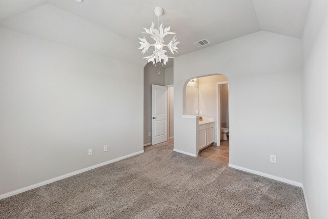 3651 Lake Bend Shore Dr, Spring, TX 77386 - unfurnished bedroom with arched walkways, a chandelier, light colored carpet, lofted ceiling, and baseboards