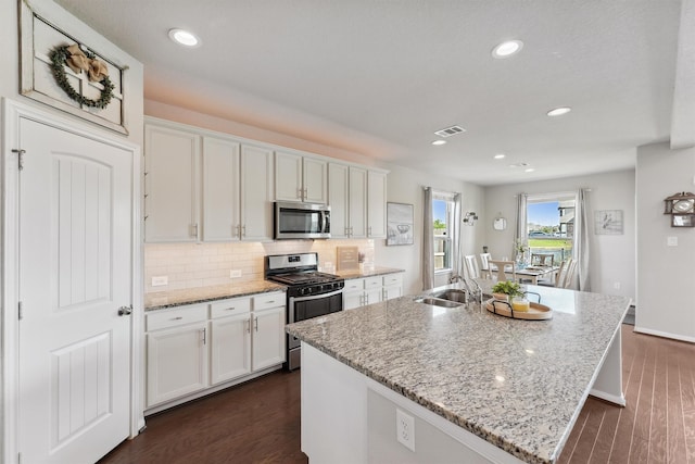 3651 Lake Bend Shore Dr, Spring, TX 77386 - kitchen featuring stainless steel appliances, a sink, white cabinets, a kitchen island with sink, and tasteful backsplash
