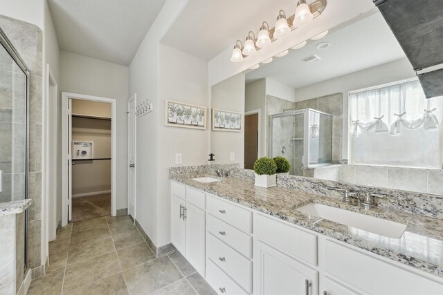 3651 Lake Bend Shore Dr, Spring, TX 77386 - full bathroom with a stall shower, double vanity, a spacious closet, and baseboards