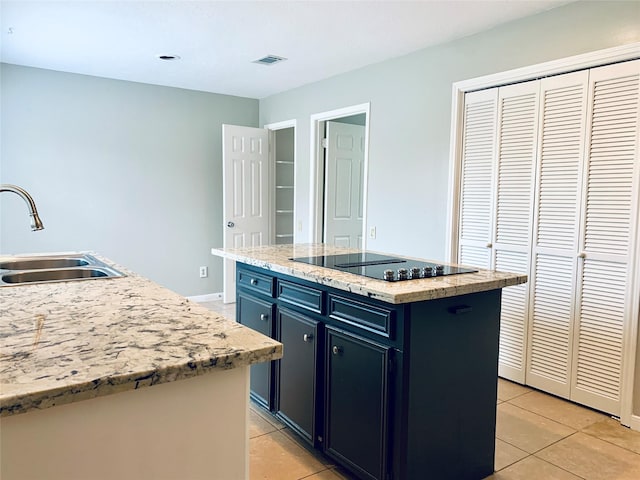 223 Kings Way, Stafford, TX 77477 - kitchen with a sink, black electric stovetop, light tile patterned flooring, a kitchen island, and baseboards