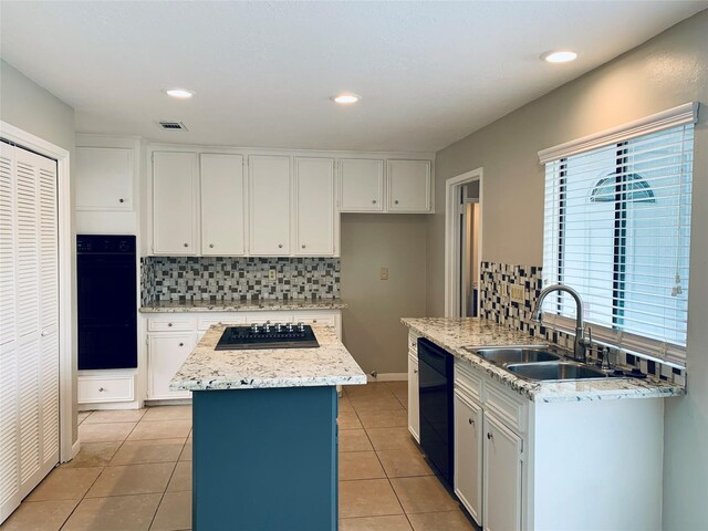 223 Kings Way, Stafford, TX 77477 - kitchen featuring black appliances, a sink, backsplash, a center island, and white cabinets