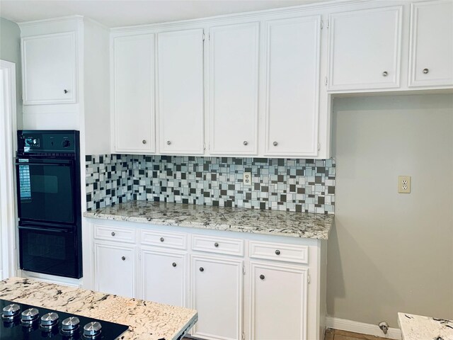 223 Kings Way, Stafford, TX 77477 - kitchen with black appliances, backsplash, white cabinets, baseboards, and light stone counters