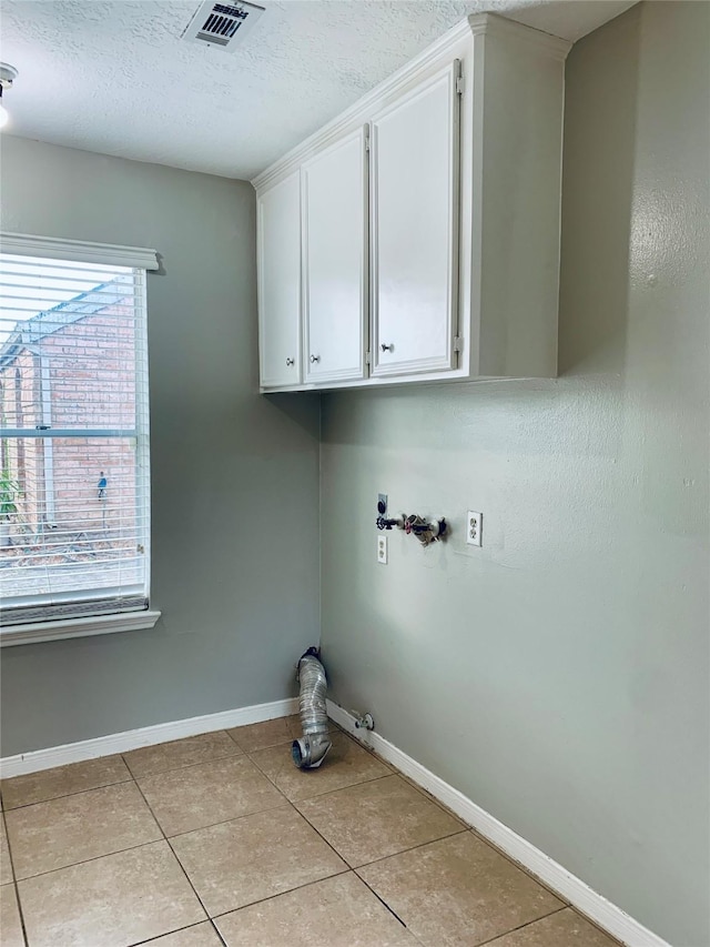 223 Kings Way, Stafford, TX 77477 - laundry area with light tile patterned flooring, electric dryer hookup, washer hookup, baseboards, and cabinet space