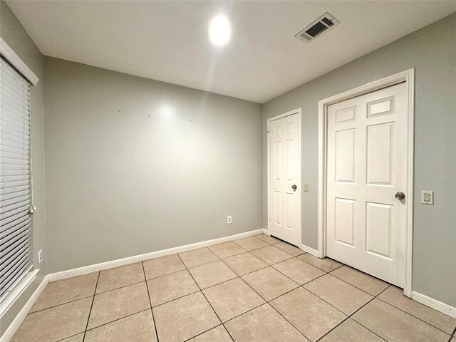 223 Kings Way, Stafford, TX 77477 - unfurnished bedroom featuring light tile patterned flooring and baseboards