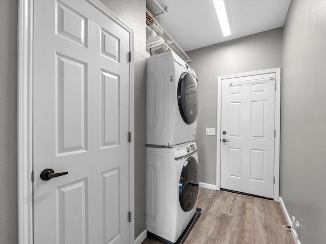 19122 High Canyon Ln, Tomball, TX 77377 - laundry area with stacked washer / dryer, light wood-style floors, and baseboards