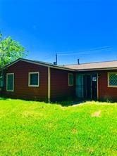 7725 St Lo Rd, Houston, TX 77033 - rear view of property with a yard