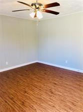 7725 St Lo Rd, Houston, TX 77033 - unfurnished room with baseboards and wood finished floors