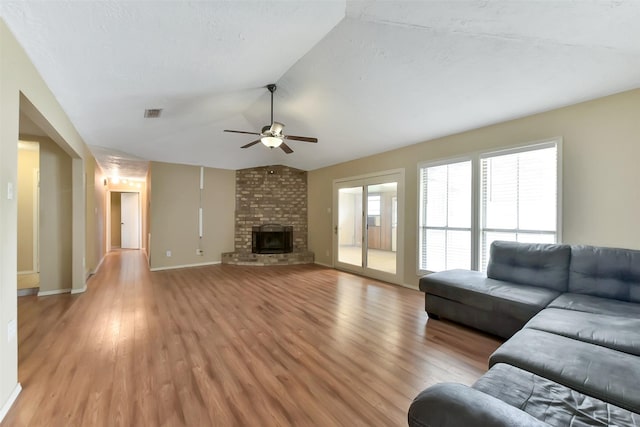 402 E Lambuth Ln, Deer Park, TX 77536 - living room featuring a ceiling fan, light wood finished floors, lofted ceiling, a brick fireplace, and baseboards