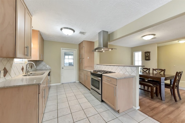 402 E Lambuth Ln, Deer Park, TX 77536 - kitchen with stainless steel gas range, island range hood, a sink, a peninsula, and decorative backsplash