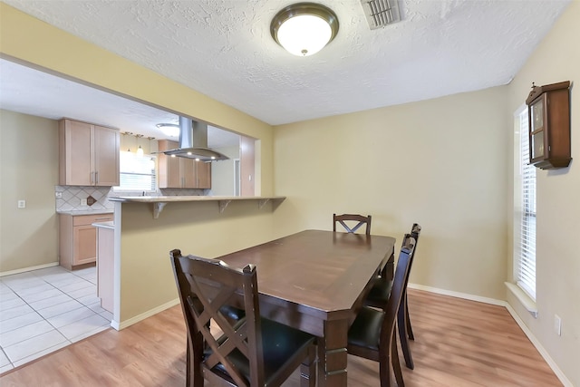 402 E Lambuth Ln, Deer Park, TX 77536 - dining space featuring light wood-type flooring, a textured ceiling, and baseboards