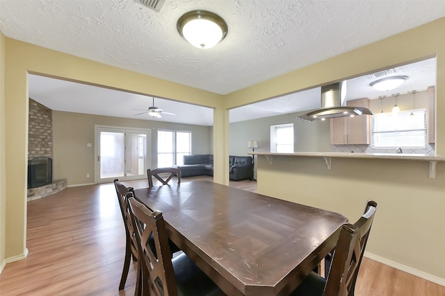 402 E Lambuth Ln, Deer Park, TX 77536 - dining space featuring light wood-style flooring, ceiling fan, a textured ceiling, baseboards, and plenty of natural light