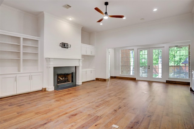 13502 Winter Creek Ct, Houston, TX 77077 - unfurnished living room featuring crown molding, a fireplace with flush hearth, light wood-style floors, a ceiling fan, and french doors