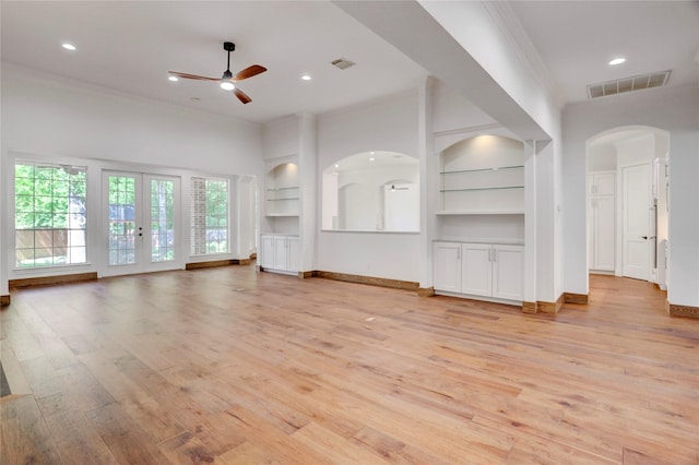 13502 Winter Creek Ct, Houston, TX 77077 - unfurnished living room with a ceiling fan, built in shelves, crown molding, light wood-style flooring, and arched walkways