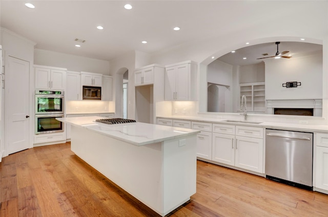 13502 Winter Creek Ct, Houston, TX 77077 - kitchen featuring appliances with stainless steel finishes, a sink, a ceiling fan, white cabinetry, and a kitchen island