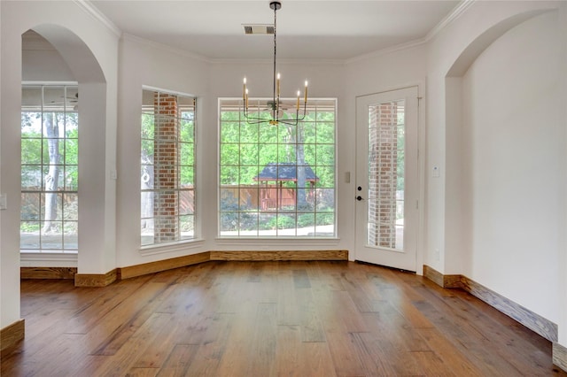 13502 Winter Creek Ct, Houston, TX 77077 - unfurnished dining area featuring wood finished floors, baseboards, a chandelier, crown molding, and arched walkways