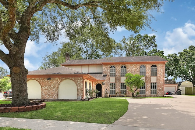 9806 Sagewell Dr, Houston, TX 77089 - view of front facade with a front yard, roof with shingles, a chimney, brick siding, and concrete driveway