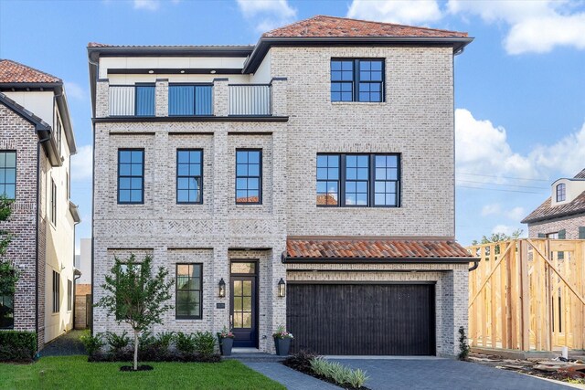 1139 Castellina Ln, Houston, TX 77055 - view of front facade featuring a balcony, brick siding, an attached garage, and driveway