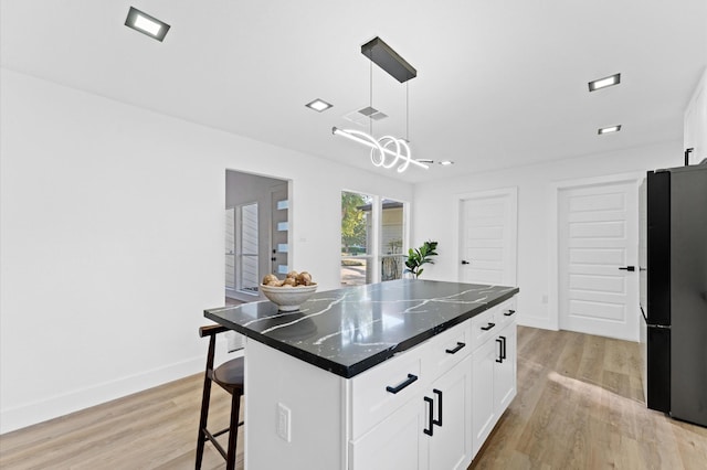 5507 Council Grove Ln, Houston, TX 77088 - kitchen featuring light wood-type flooring, a center island, and white cabinetry