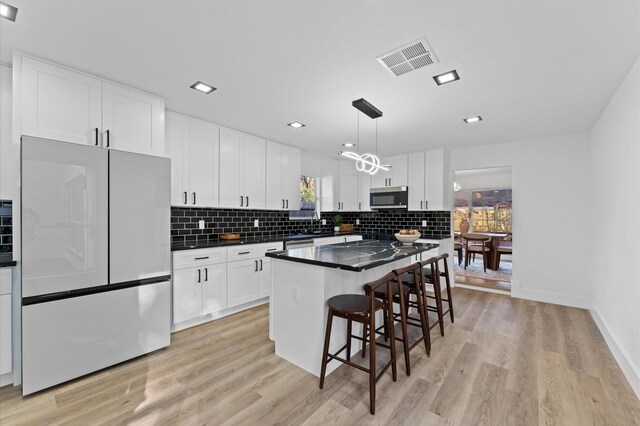 5507 Council Grove Ln, Houston, TX 77088 - kitchen with stainless steel appliances, light wood finished floors, a center island, a kitchen bar, and recessed lighting