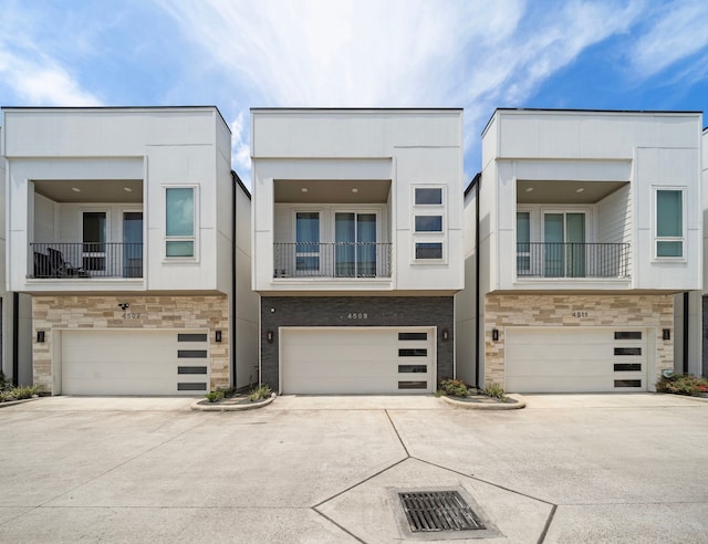 4509 Whitney Park Way, Houston, TX 77022 - townhome / multi-family property featuring a garage, stone siding, concrete driveway, and stucco siding