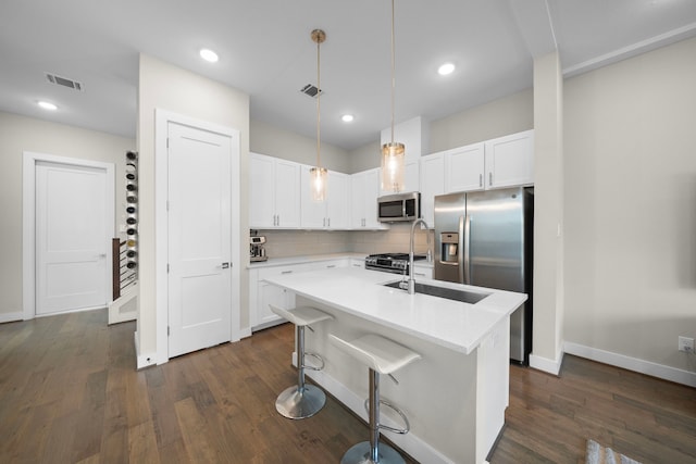 4509 Whitney Park Way, Houston, TX 77022 - kitchen featuring stainless steel appliances, dark wood-style flooring, white cabinetry, light countertops, and decorative backsplash