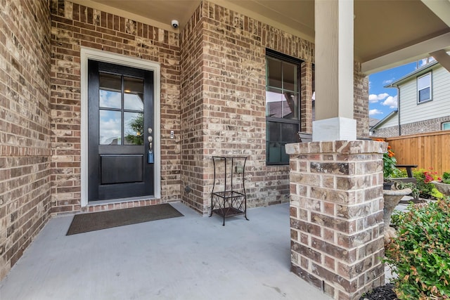 15818 Grampian Reach Ln, Humble, TX 77346 - view of exterior entry featuring brick siding, covered porch, and a security system
