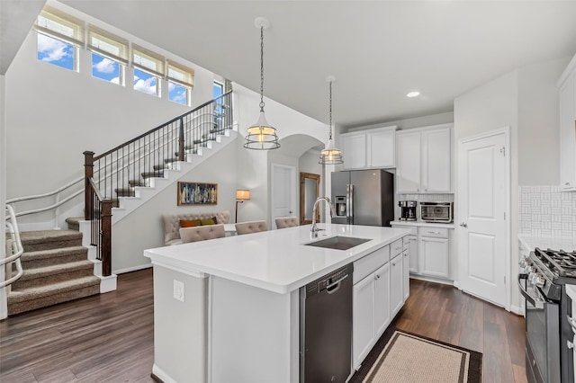 15818 Grampian Reach Ln, Humble, TX 77346 - kitchen featuring appliances with stainless steel finishes, dark wood finished floors, tasteful backsplash, recessed lighting, and white cabinets