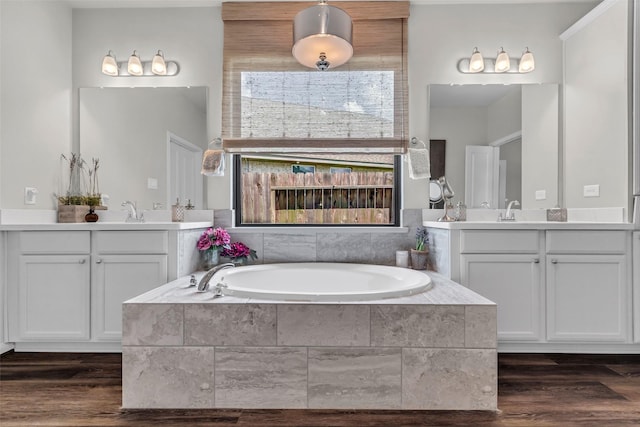 15818 Grampian Reach Ln, Humble, TX 77346 - full bathroom with two vanities, a garden tub, and wood finished floors