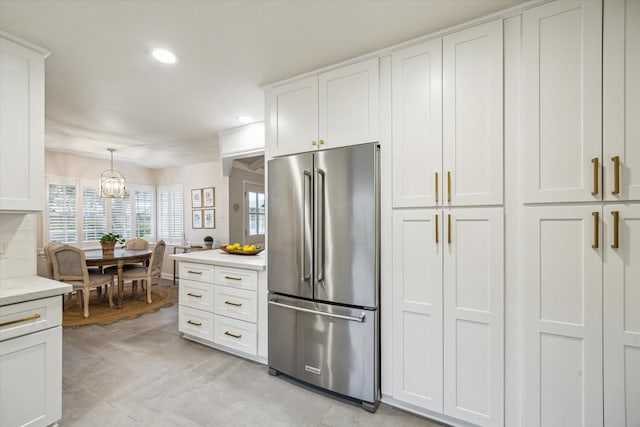 7810 Pagewood Ln, Houston, TX 77063 - kitchen featuring high end fridge, light countertops, a chandelier, white cabinets, and recessed lighting